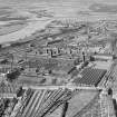 Oblique aerial view centred on Singer Sewing Factory, Clydebank, with the railway station adjacent with John Brown's shipbuilding yard in the background, taken from the E.
