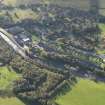 Oblique aerial view centred on the mills with the cottages adjacent, taken from the NW.