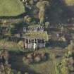 Oblique aerial view centred on the ruins of the country house with the stables adjacent, taken from the SE.