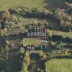 Oblique aerial view centred on the ruins of the country house with the stables adjacent, taken from the NW.