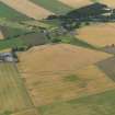 General oblique aerial view of the cropmarks of the rig and furrow with Eassie old parish church beyond, taken from the NNE.