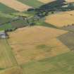 General oblique aerial view of the cropmarks of the rig and furrow with Eassie old parish church beyond, taken from the N.