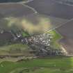 Oblique aerial view centred on the village with the parish church adjacent, taken from the N.