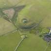 Oblique aerial view centred on Cubbie Roo's Castle with St Mary's Chapel and The Bu farmstead adjacent, taken from the E.