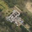 Oblique aerial view centred on the fire damaged house, taken from the NW.