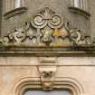 Detail of ornate carved main entrance door pediment with 'owl' motif and nailhead decoration.