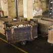 Interior. 1950s block, ground floor, winding shed, detail of basket and tubs for transporting bobbins