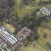 Oblique aerial view centred on the country house with the stables adjacent, taken from the NW.