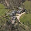 Oblique aerial view centred on the country house with the stable block adjacent, taken from the NNE.