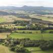 General oblique aerial view of the remains of the recumbent stone circle and enclosed cremation cemetery at Loanhead of Daviot with Mither Tap of Bennachie in the distance, taken from the SW.