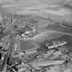 Oblique aerial view centred on Thomas Ward and Sons Shipbreaking Yard and Caldwells Paper Mill, Inverkeithing, in 1947, facing north-east. The vessels include a mine damaged large bulk carrier, a small bulk carrier, two large passenger liners and a general cargo ship.