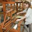View of student working at a loom within the weaving studio of the Newbery Tower