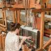 View of student working at a loom within the weaving studio of the Newbery Tower
