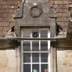 Detail of east dormer window with carved stone pediment at 1st floor level of south facade
