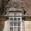 Detail of west dormer window with carved stone pediment at 1st floor level of south facade