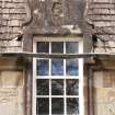 Detail of north dormer window with carved stone pediment at 1st floor level of east facade