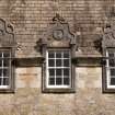 Detail of three dormer windows with carved stone pediments at 2nd floor level of west facade