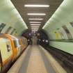 View looking along the island platform of Cowcaddens subway station, towards the tunnel openings and fire exit, with a train waiting at the Outer Circle platform