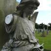Detail of a statue of an angel reading, with arm missing. Morningside Cemetery, Edinburgh.