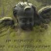 Detail of headstone relief of the head and wings of an angel, 'in loving memory of our parents', Canongate Kirk Cemetery, Edinburgh.