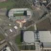 Oblique aerial view of of the Sir Chris Hoy Velodrome and Parkhead football stadium, looking to the NE.