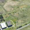 Oblique aerial view of mining sheds connected to US Naval Base 17 at Dalmore and hut bases, bomb shelters and amunition stores connected to the RAF Seaplane Base at Alness Point, looking S.