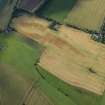 Oblique aerial view of the cropmarks of the sunken floored building, the enclosure, pits and rig, looking NNW.