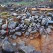 East-north-east facing inner face of the enclosure wall in Trench 3, partially collapsed with rubble spread over the north west end; plan view of section through redeposited natural ('slopewash') in front centre of image, Comar Wood Dun, Cannich, Strathglass