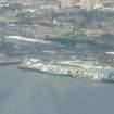 Low angle aerial view of part of Dundee waterfront backed by the historic Cowgate Port (aka East Port) area of the city, looking N.