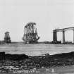 View of the Forth Bridge under construction. 
Titled: 'The Forth Bridge. Length including Viaduct 8098 Ft. Height 369 Ft. Spans 1710 Ft each.  614'