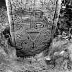 View of architectural fragments.  Artifically lit detail photograph of medieval graveslab in reuse as gatepost on S side of entrance, NY 2577 8019.