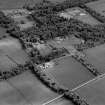 Oblique aerial view centred on the farmsteading, kennels and cottage with country house and formal garden adjacent, taken from the NNW