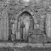 General view of cross-slabs, Pictish symbol stone, other carved stones and medieval doorway in railed enclosure.
Original negative captioned: 'Sculptured Stones at Old Church of Tullich near Ballater July 1902'.