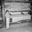 Interior
View showing woman standing beside beetling machine