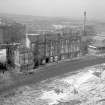 View looking NW showing SE front of Coop buildings with tenement and public house on left and school in background