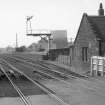 View looking W showing SSE fronts of original station building with level crossing in foreground