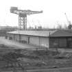 View from NE showing NNE and ESE fronts of E goods shed with crane in background