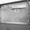 View of goods shed showing sign which is inscribed 'CONSTANTINE LINES LTD FOR MARSSILLES. ITALY. SICILY APPLY to 120 ST VINCENT ST.' and 'SAGUENANY SHIPPING LTD FOR TRINIDAD. BARBADOS. DEMERARA PHONE CITY 6171'