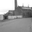 View looking NNE showing base of chimney and part of WSW and SSE fronts of weaving sheds