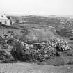 Tiree, Caoles. 
General view of mill with more recent croft behind and millstone being re-used as stepping stone.