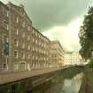 New Lanark: view from E of lade as it passes in front of Mill No. 3, with Mills No. 2 and 1 in the distance