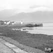 View from WNW showing lighthouse and wooden piled pier at entrance to Caledonian Canal