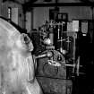 Interior.
View of Hydro-electric power station, Dunecht Estate, Garlogie, Aberdeenshire, installed by Viscount Cowdray in the early 20th century. This view shows part of the Brown Boveri turbine, with the speed governor in the background.
Copy of 35 mm black and white negative.
