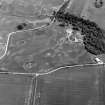 Oblique aerial view centred on the cropmarks of the timber hall, ring ditch, enclosures and pits at Mondobbo House, looking to the NE.
