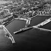 Oblique aerial view centred on the harbour with the town adjacent, taken from the NE.