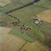 Oblique aerial view centred on the farmsteading and the remains of the abbey, taken from the NW.