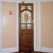 Interior. Crush area, detail of door with stained glass leading to Ladies lavatory
