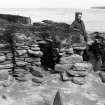Excavation photograph showing Vere Gordon Childe at Hut 4 Door and cell 2, Skara Brae.