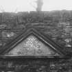 Edinburgh, Gorgie Road, Gorgie House.
Detail of a sculptured window pediment inserted in a wall.
Insc: 'GMB 1710'.
