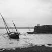 View of yacht in unidentified harbour (possibly Capernaum) at low tide. 
Scanned from original glass plate negative by Erskine Beveridge